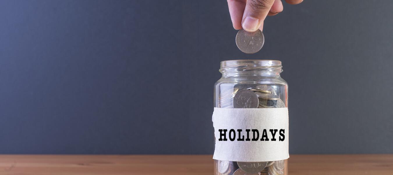 putting coin into "holidays" jar